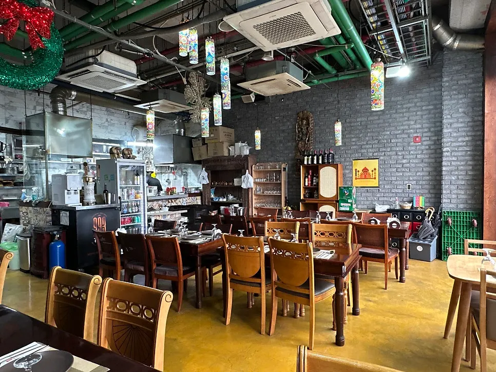 Interior with wood-toned furniture and Indian-style decor