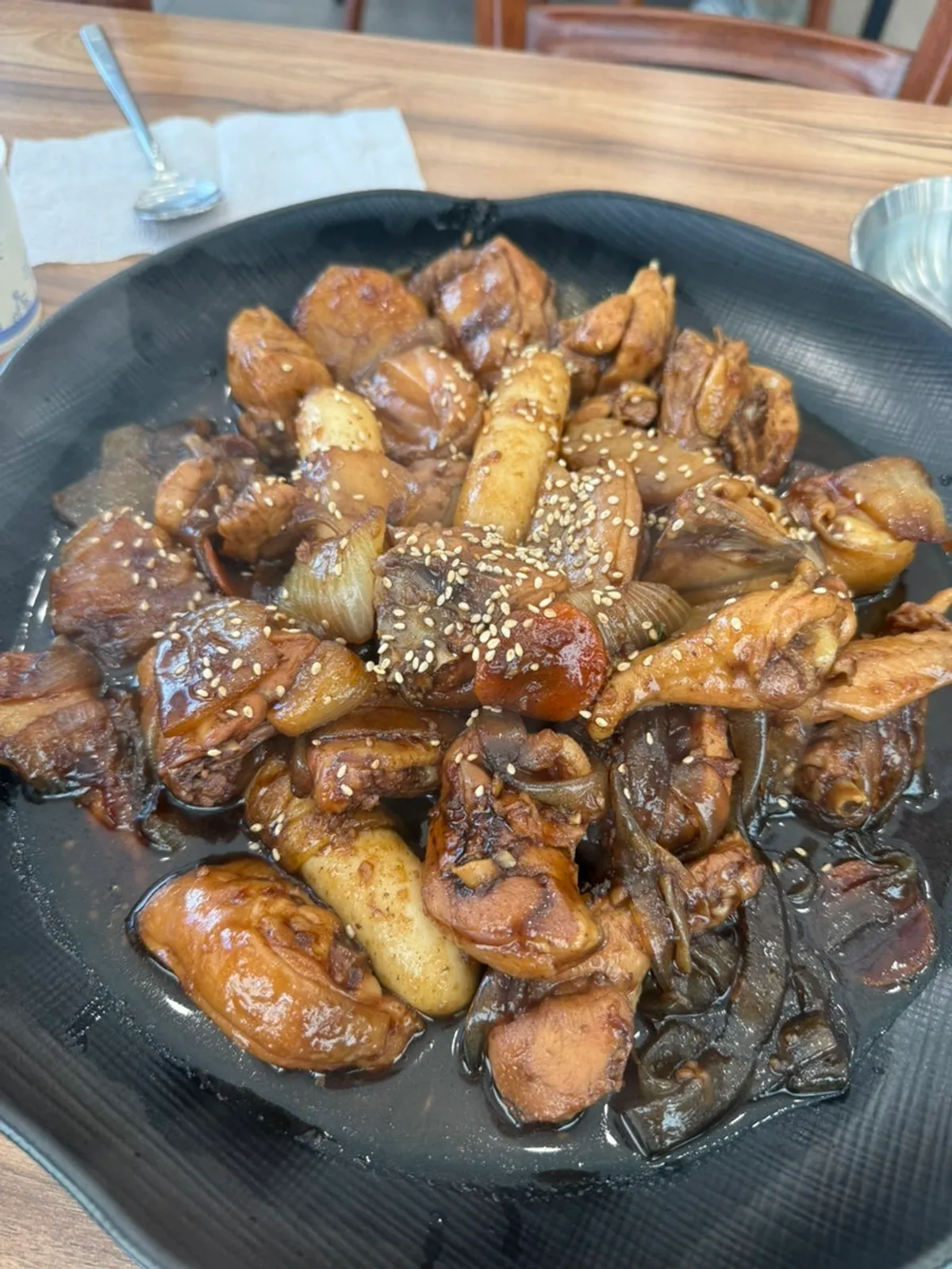A full serving of traditional soy jjimdak with flat noodles and rice cake