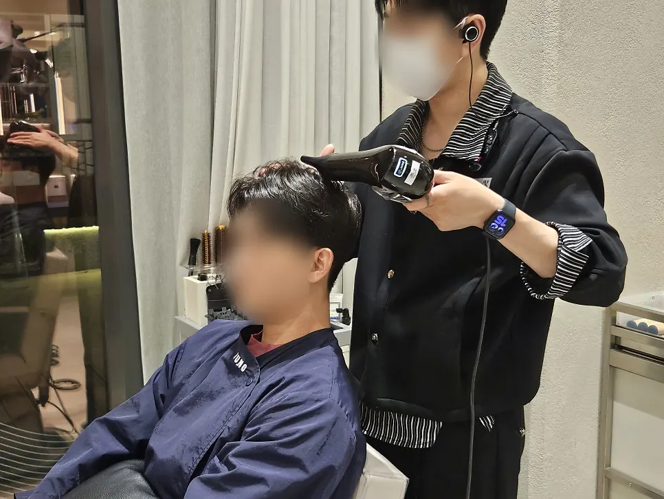 Designer Junbo cutting hair for the men's cut