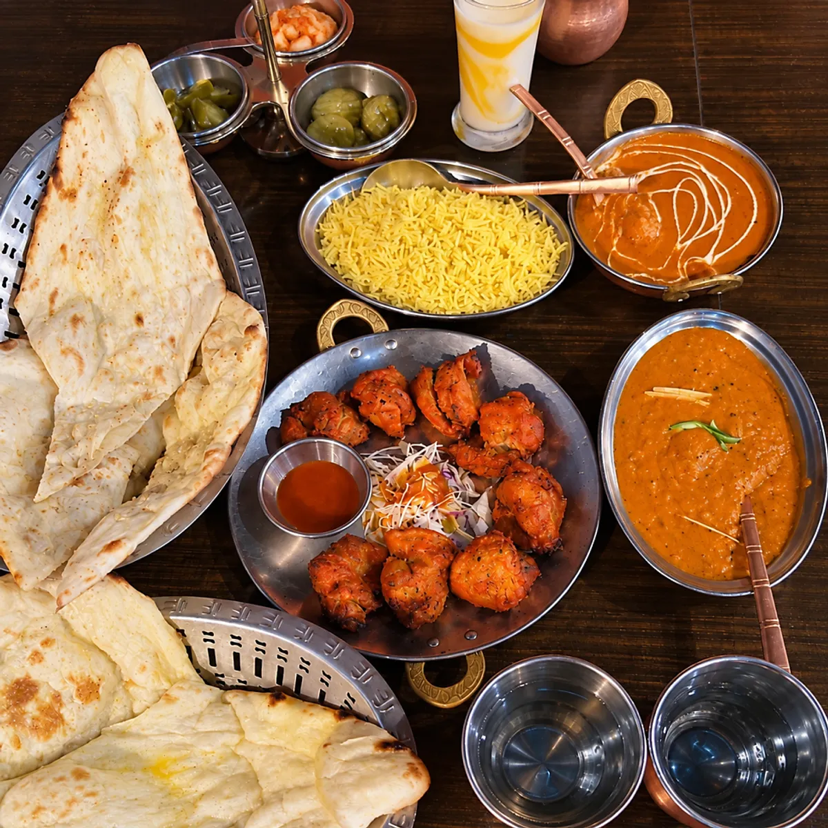 Table spread for three with curry, naan, and chicken tikka