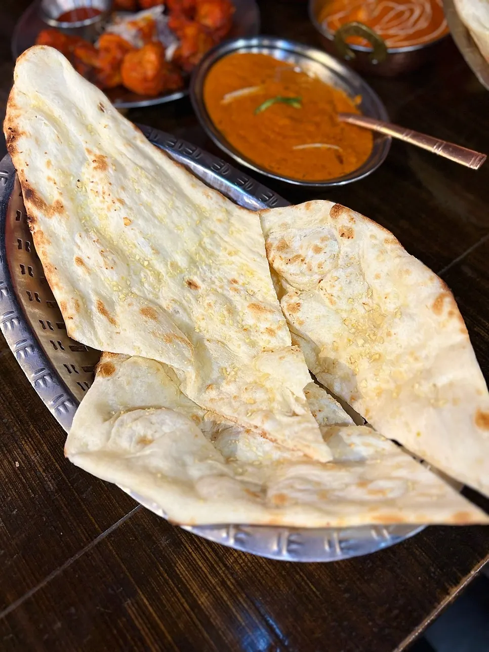 Tearing naan to dip into curry