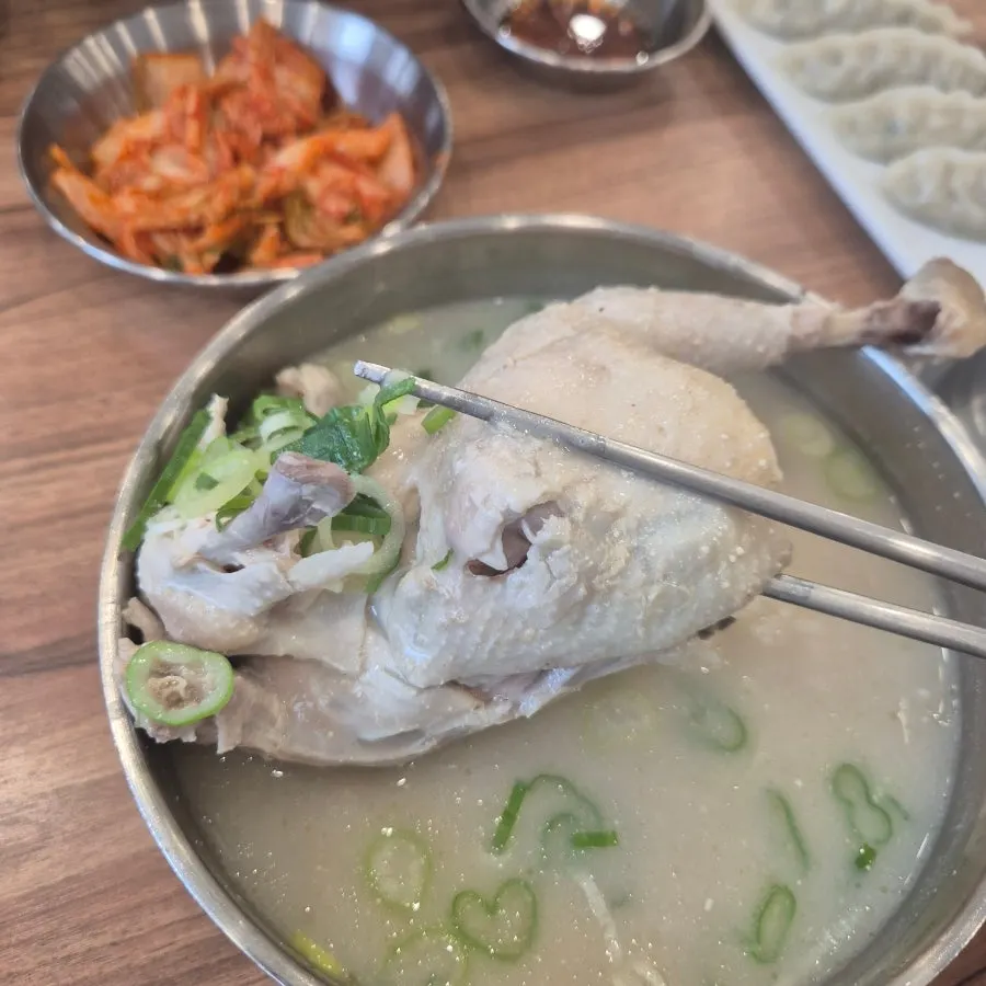 A bowl of chicken kalguksu with half a chicken inside
