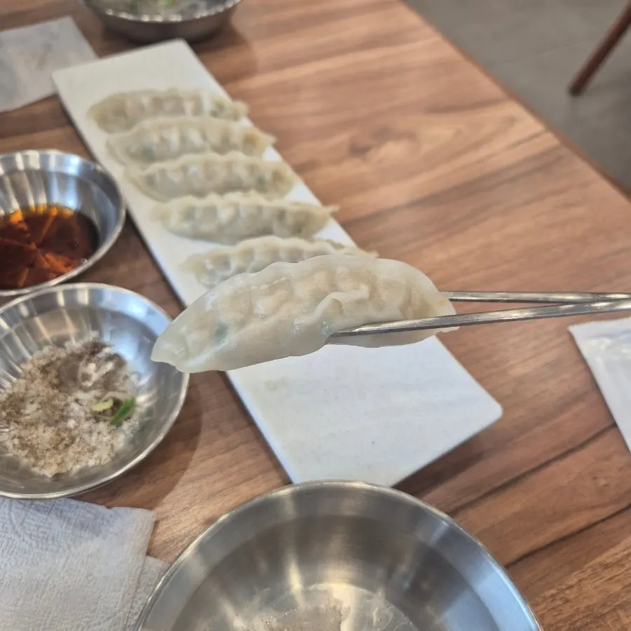 Chopsticks picking up a piece of chewy mandu
