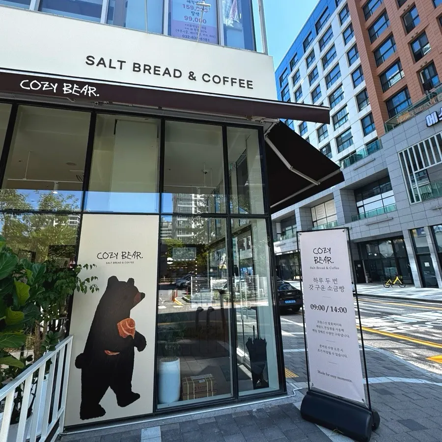 Cafe Cozy Bear sign shaped like a bear holding salt bread