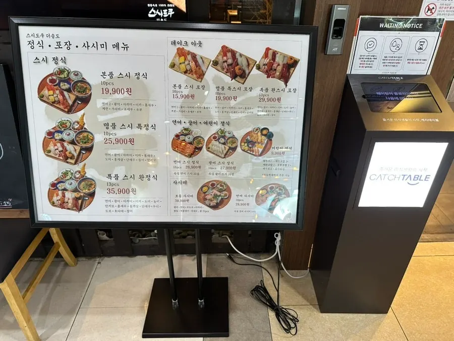 Waiting seats at Sushi Doku The Songdo with the menu posted