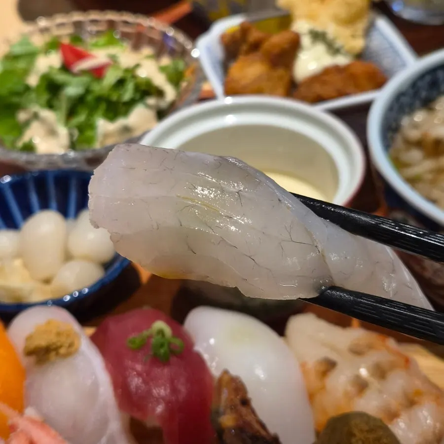 Picking up a piece of sashimi sushi