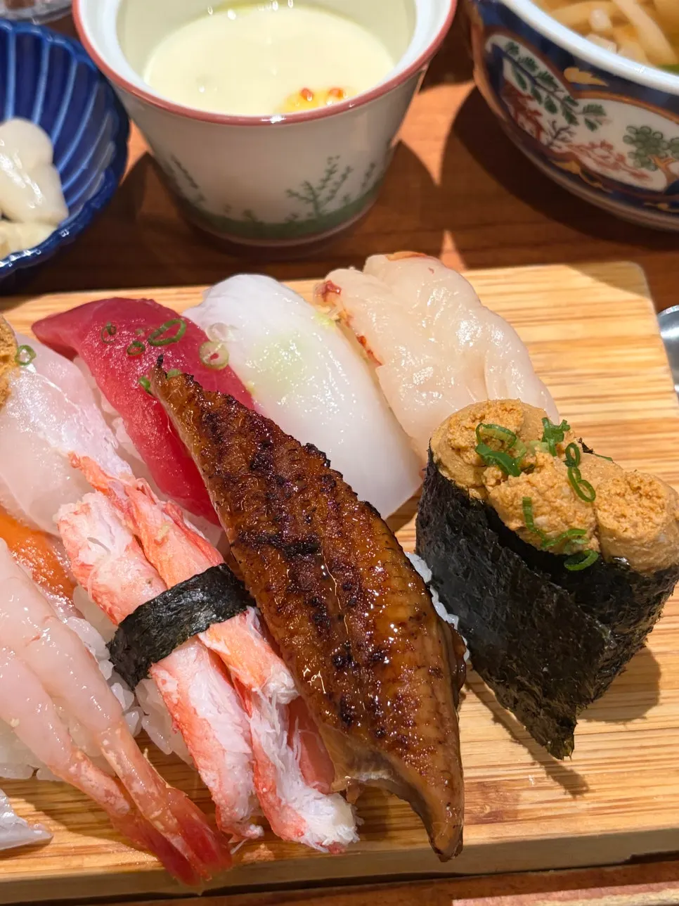 Salad with tangy dressing alongside a sushi plate