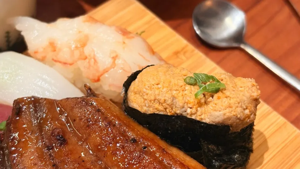 A piece of sushi topped with thick fish