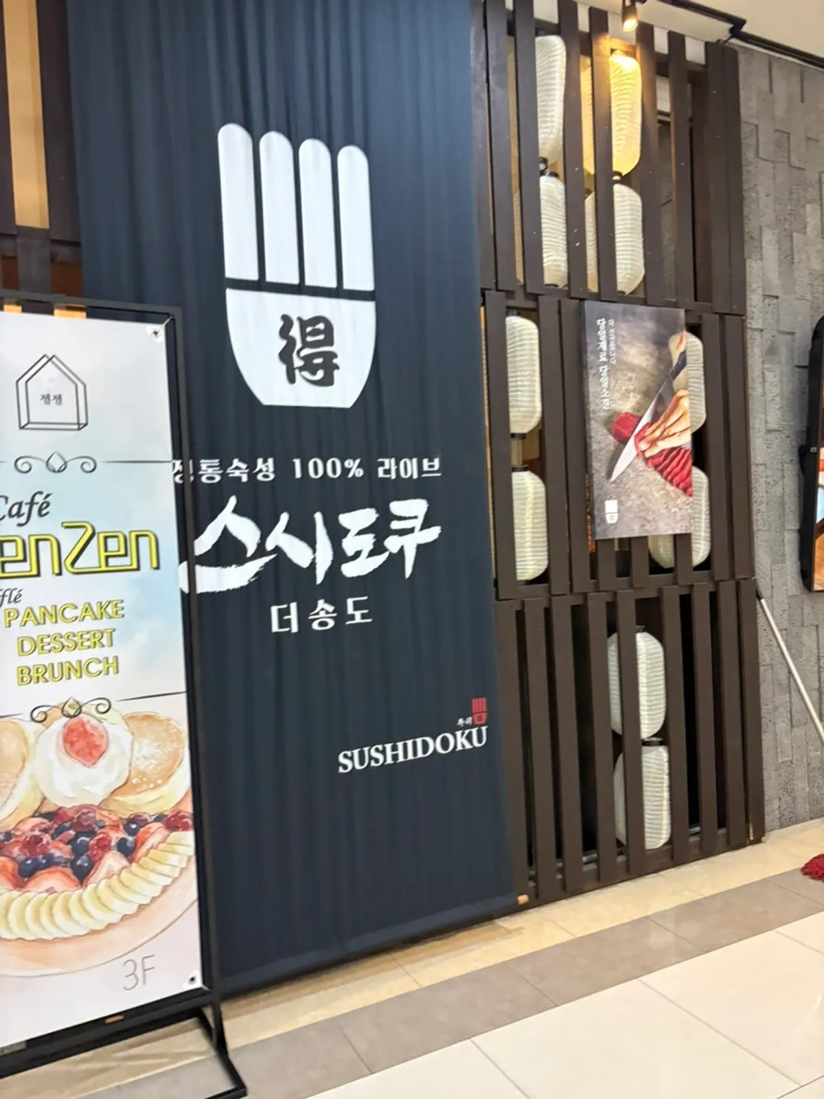 짙은 나무 인테리어의 스시도쿠 더송도 내부