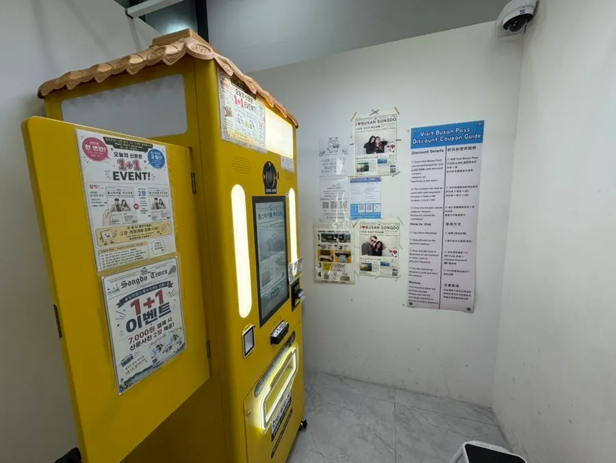 Yellow kiosk with black-and-white newspaper photo samples