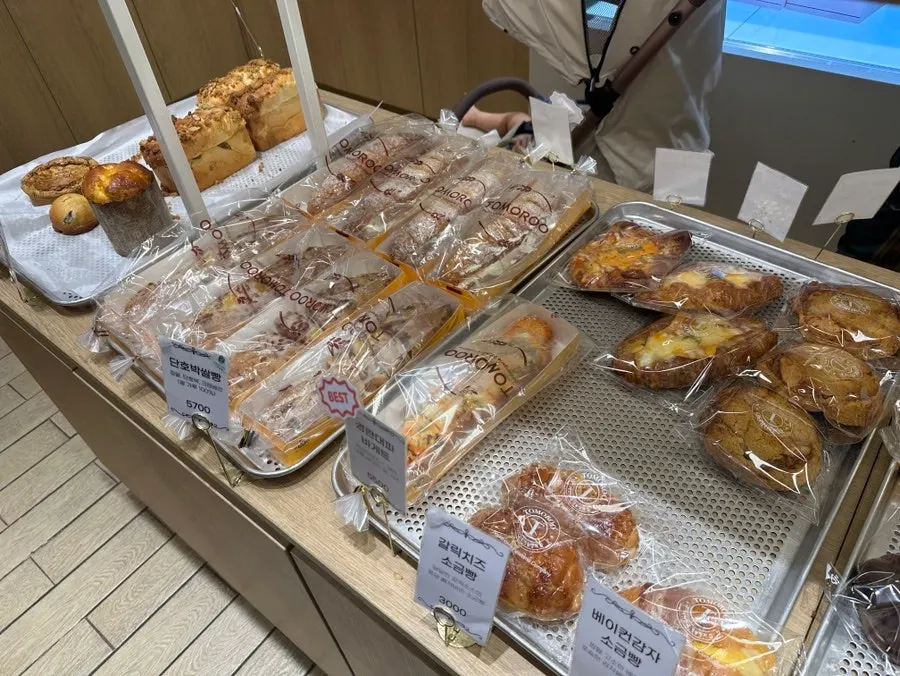 Display of basil tomato ciabatta, campagne and other plain breads