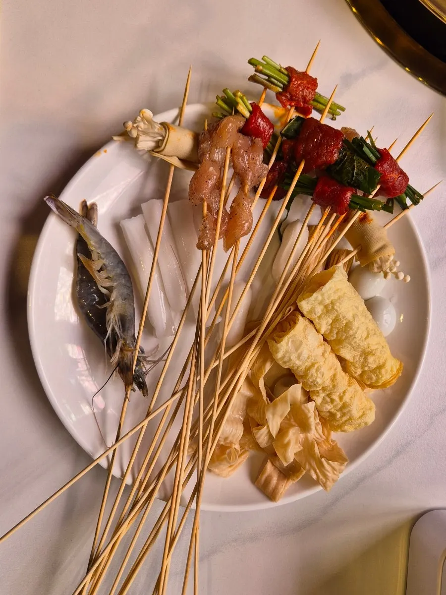Skewers of dried tofu wrapped around enoki mushrooms