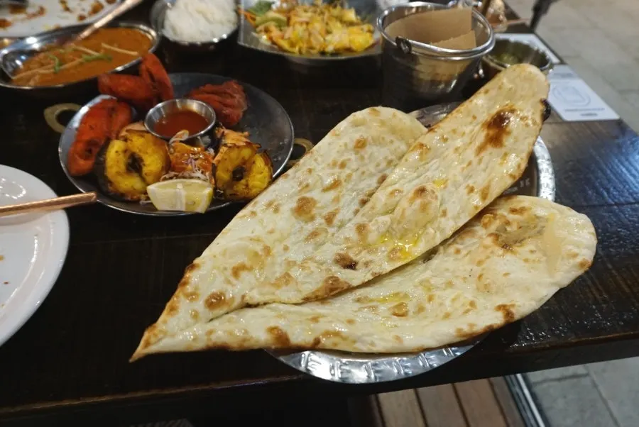 Chicken masala curry with large chicken chunks and butter naan