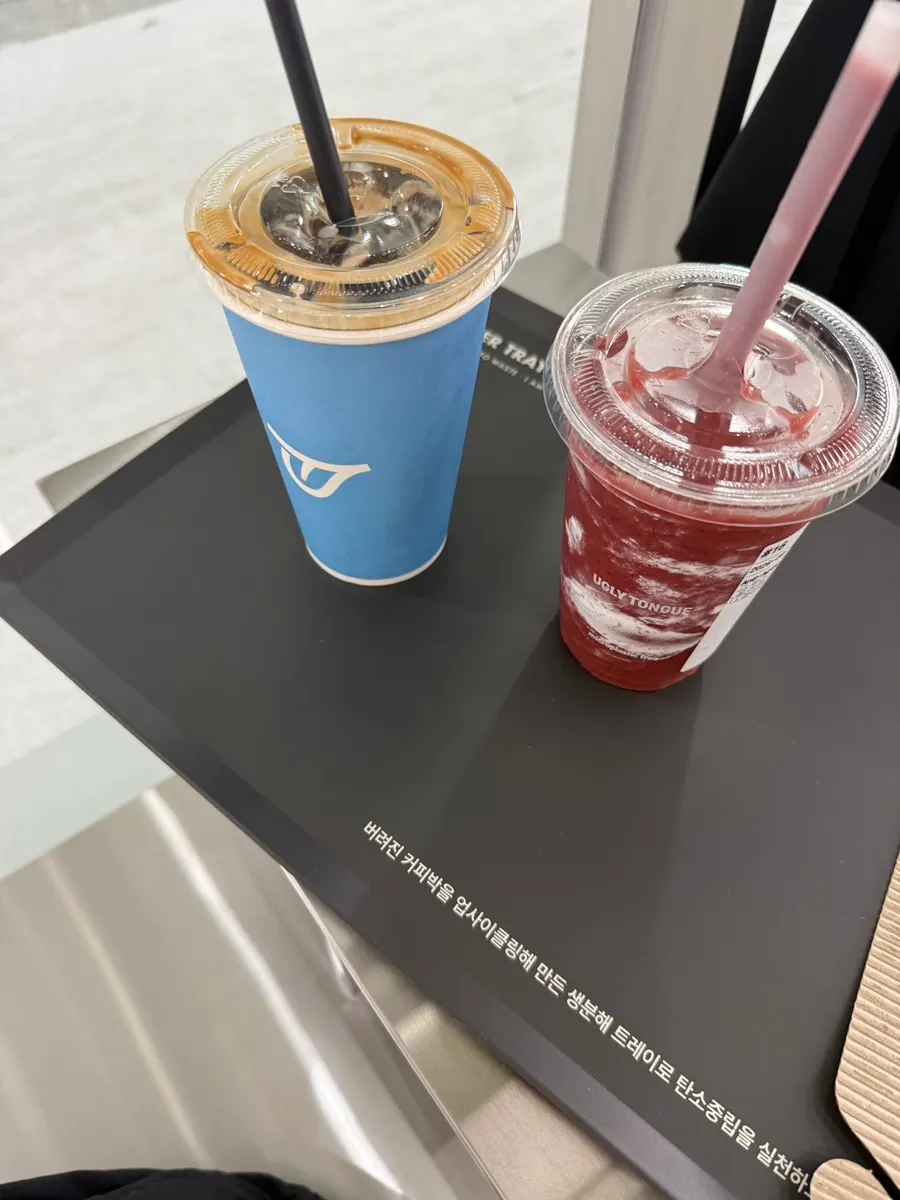 붉은 스무디와 파란 커피 컵을 나란히 놓은 테이블