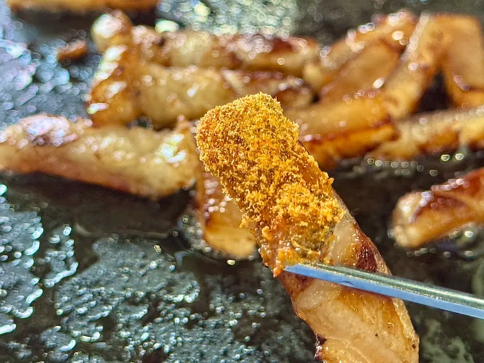 Scored pork rind grilled over charcoal