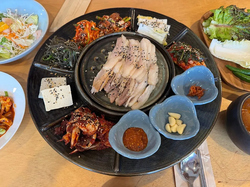 Gabrisal bossam with seasoned crab, green onion kimchi, and other banchan
