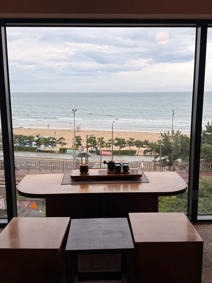 Share table seating in front of the floor-to-ceiling window