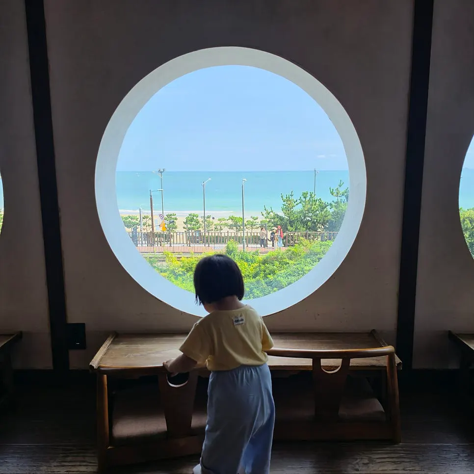Songjeong beach and the beach train seen through the round window