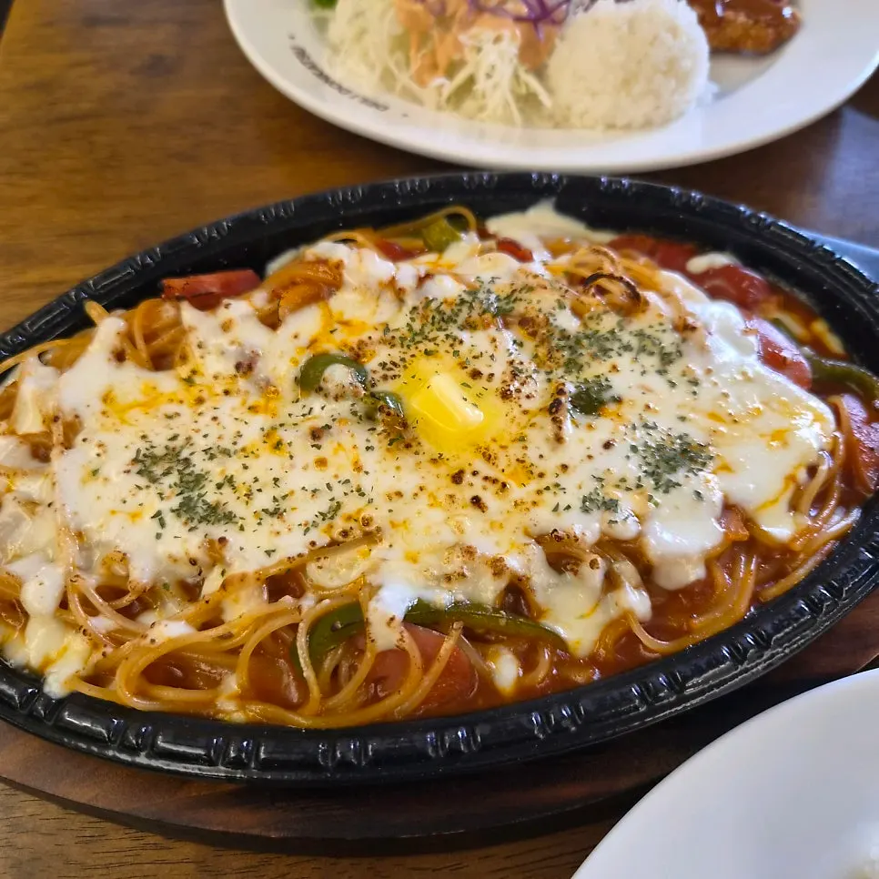 Cheese Napolitan spaghetti on a hot plate topped with plenty of cheese