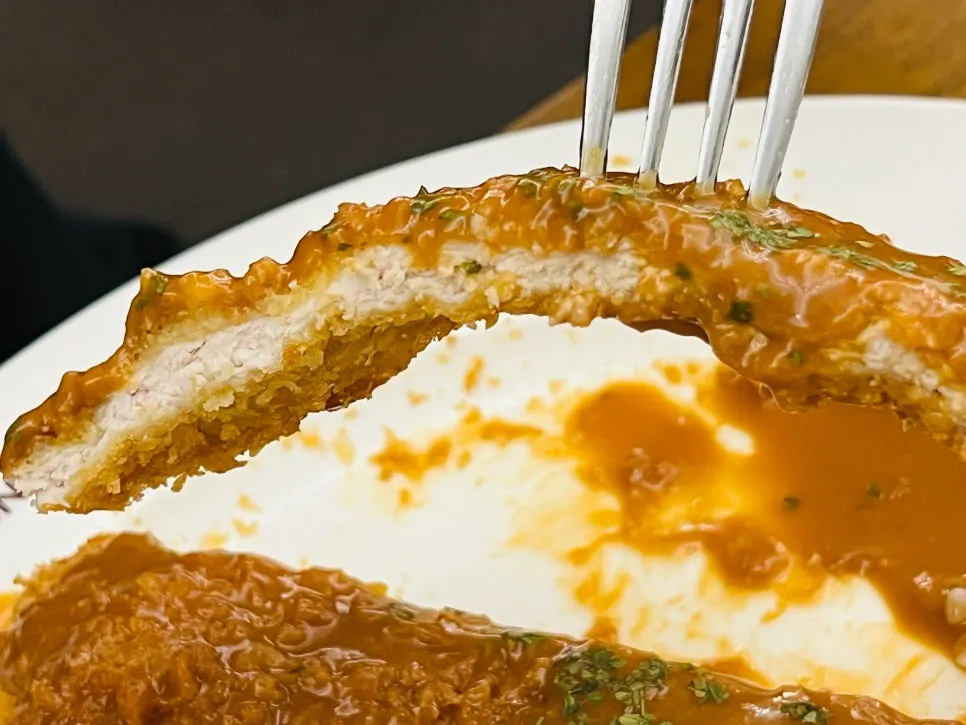 Cross-section of the pork cutlet topped with old-school sauce
