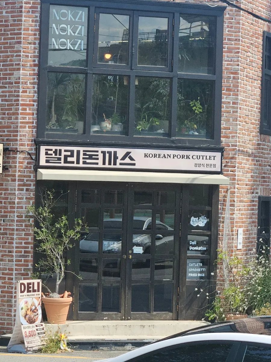 Deli Donkatsu entrance with black-framed windows and door
