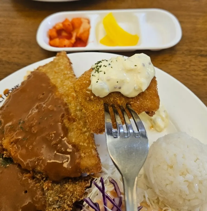 Close-up of fish cutlet topped with sauce