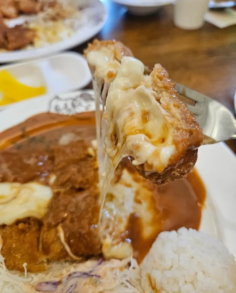 Cheese oozing out as the cheese pork cutlet is cut