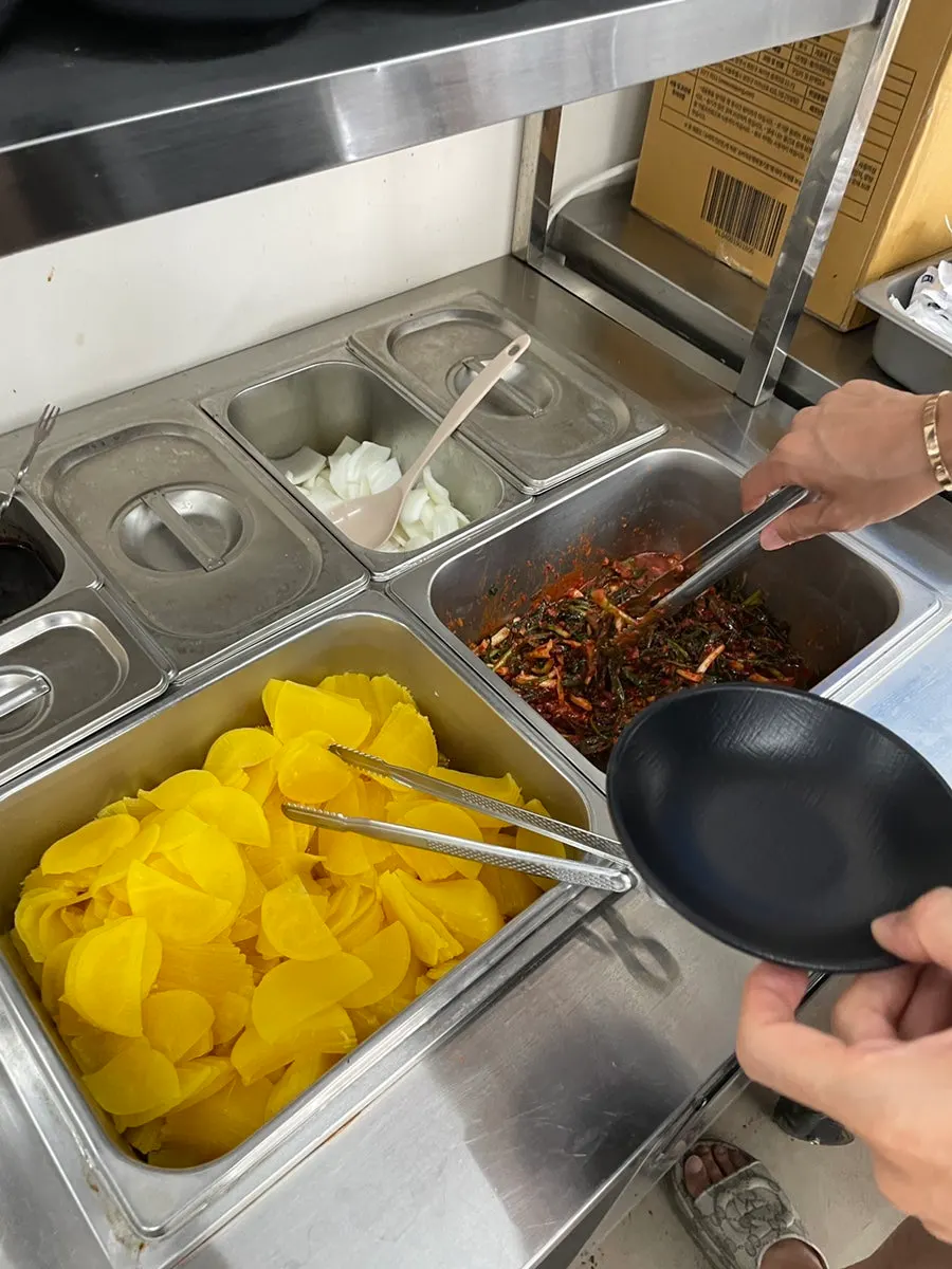 Basic side dishes of pickled radish and onion, plus self-serve green onion kimchi