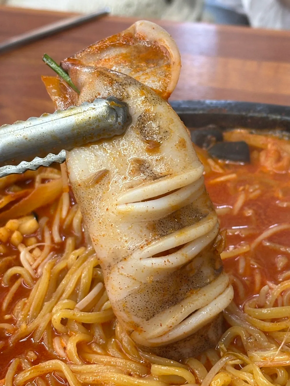 Whole squid stone-plate jjamppong topped with bean sprouts and whole squid