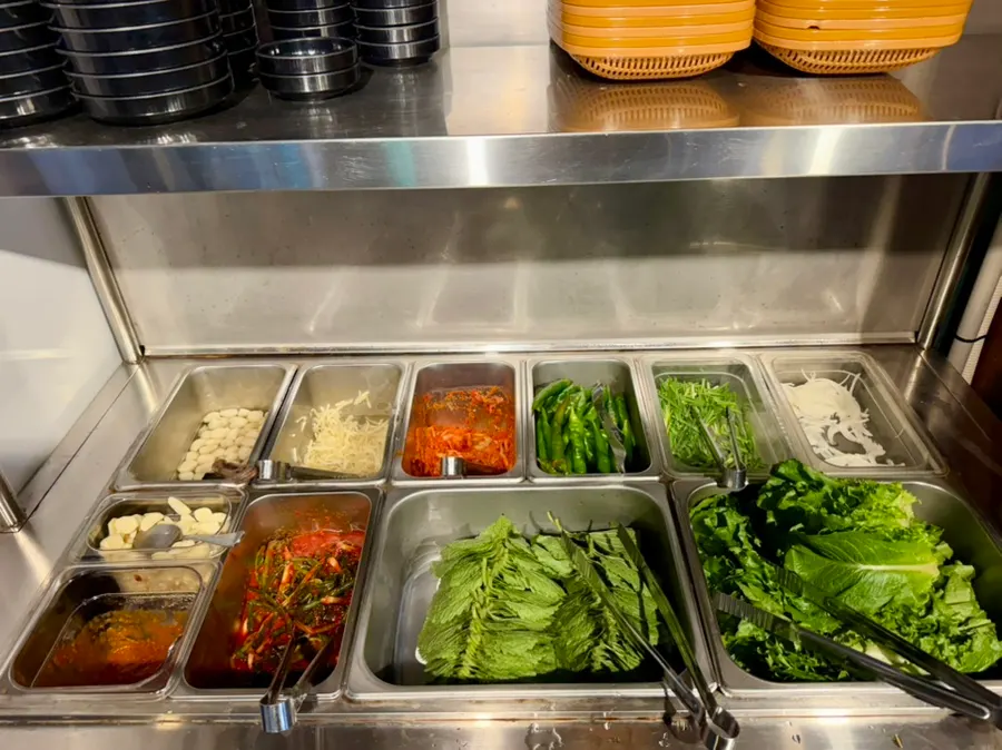 Self-serve bar with vegetables and sauces