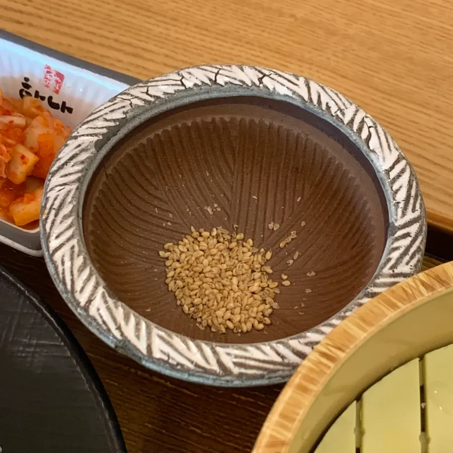 Grinding sesame seeds in a mortar to make the tonkatsu sauce