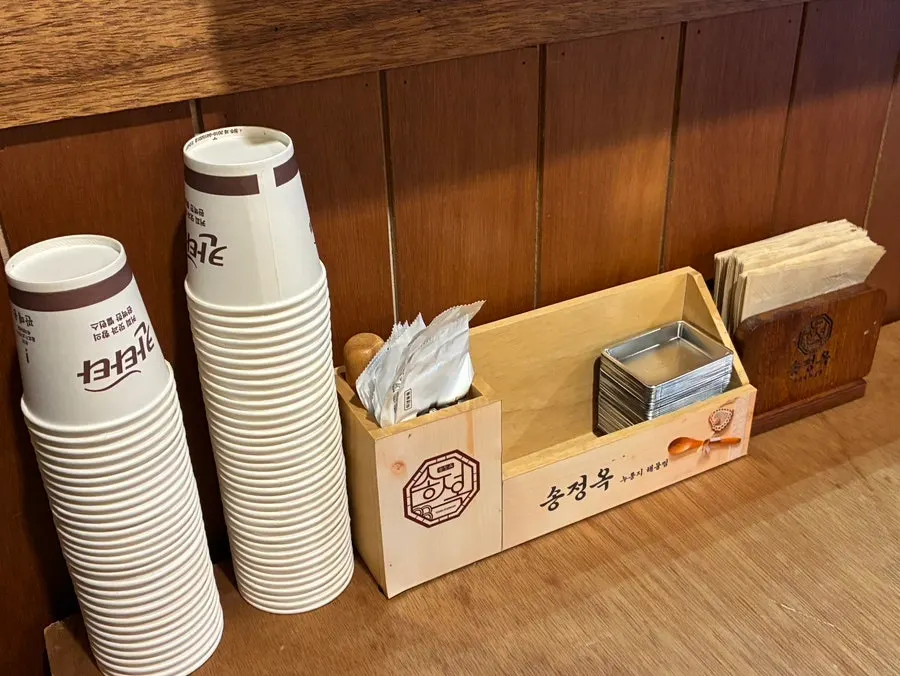 Table setting with paper cups, wet wipes, and a soy sauce dish