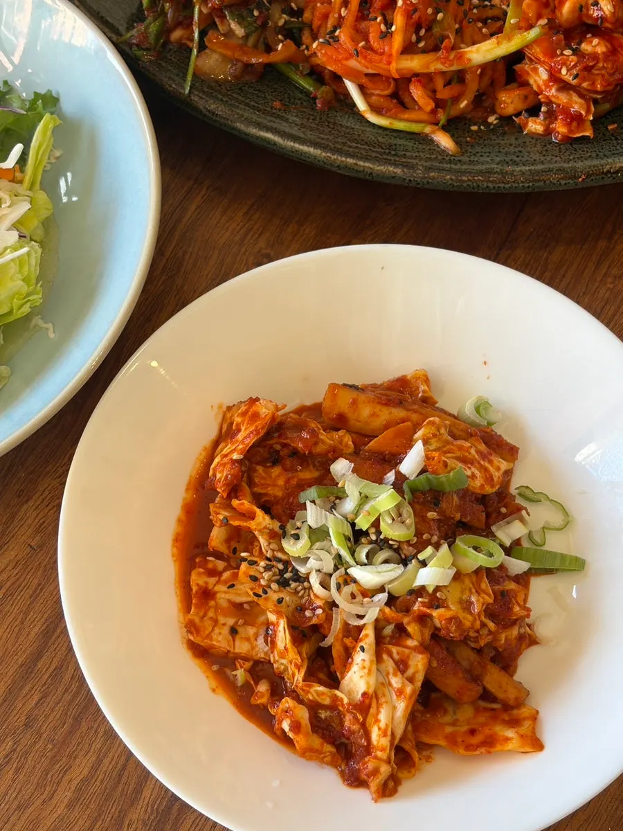 Korean side dishes including salad, kimchi, and seasoned vegetables