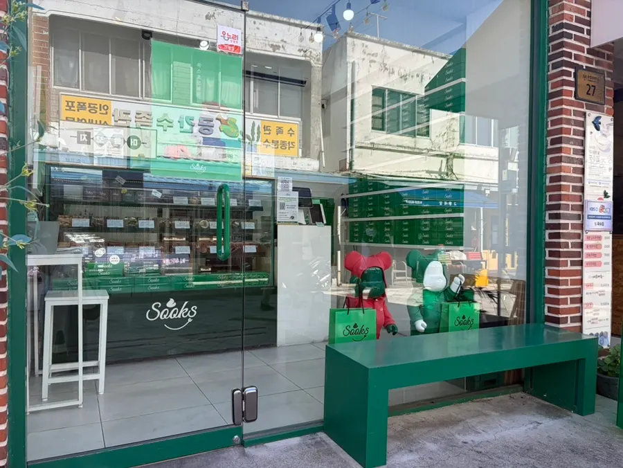 Entrance with the green sign of Ssukseu Choco Pie next to the noodle shop
