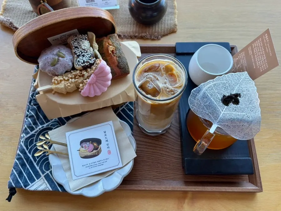 창가 테이블에 놓인 음료와 디저트 상자
