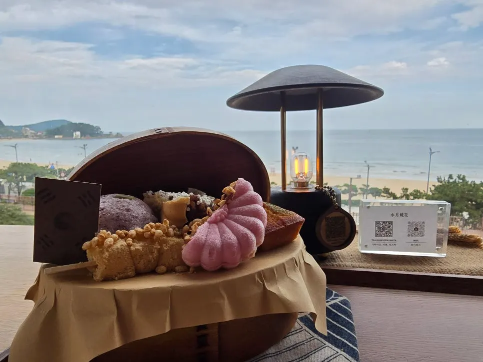 바다 배경의 디저트 상자와 음료 상차림