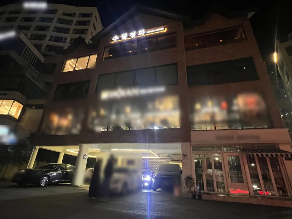 Exterior of the Suwolgyeonghwa building lit up at night in Songjeong