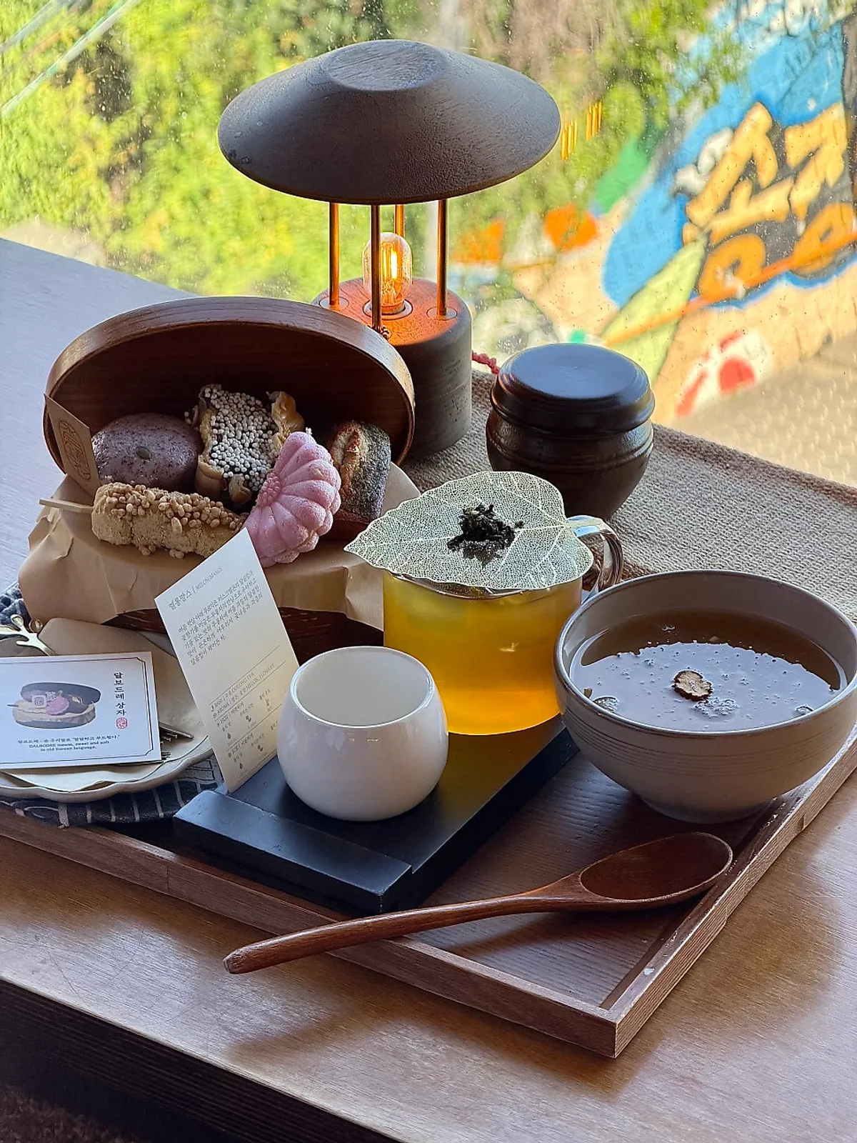 A table set with tea and desserts at the window seat of Suwolgyeonghwa