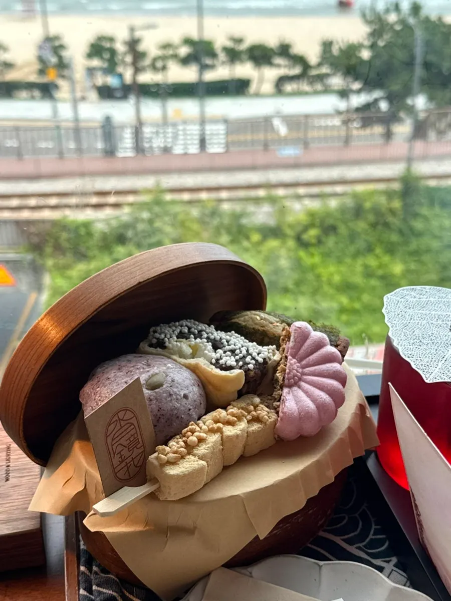 오션뷰 창가에 놓인 차와 달보드레 상자