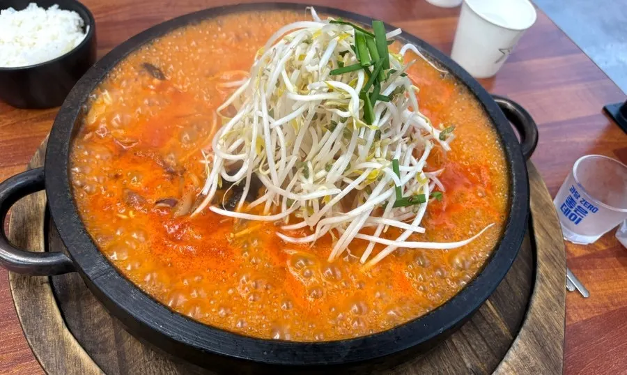 Dol jjamppong noodles and seafood topped with bean sprouts