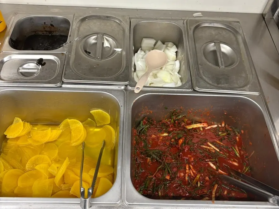 Self-serve corner with onion, danmuji, and green onion kimchi