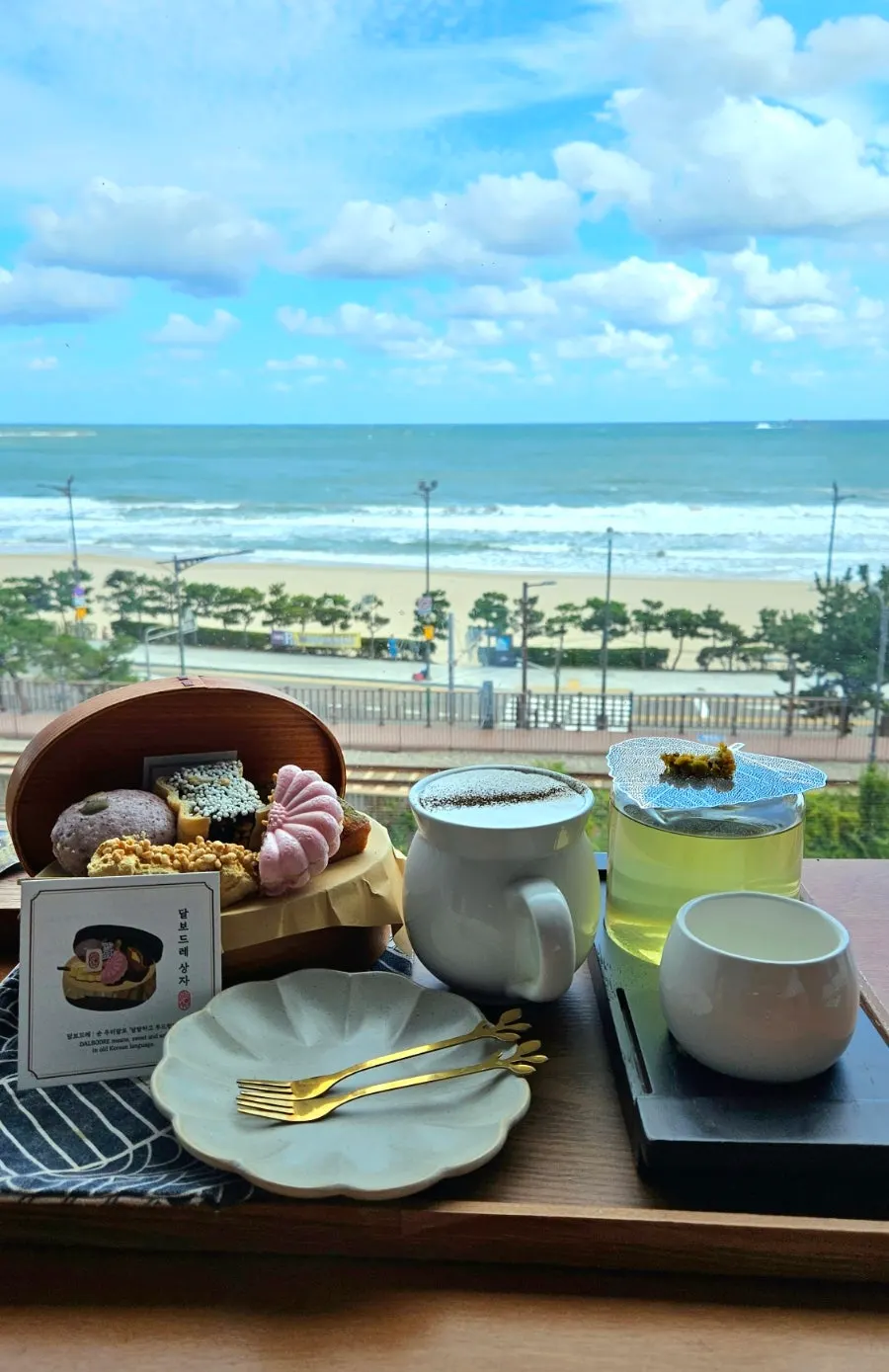 Ordered menu items set against the Songjeong sea view