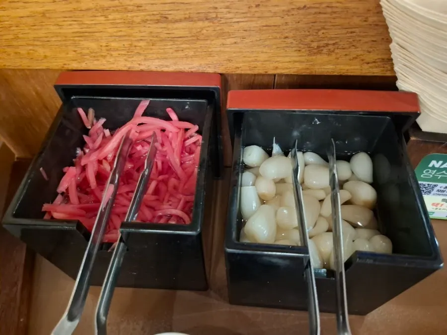 덮밥 세 그릇과 사이드가 차려진 테이블
