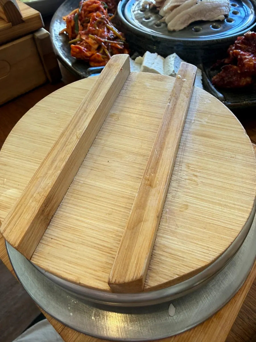 Lid opened on an individual serving of abalone pot rice