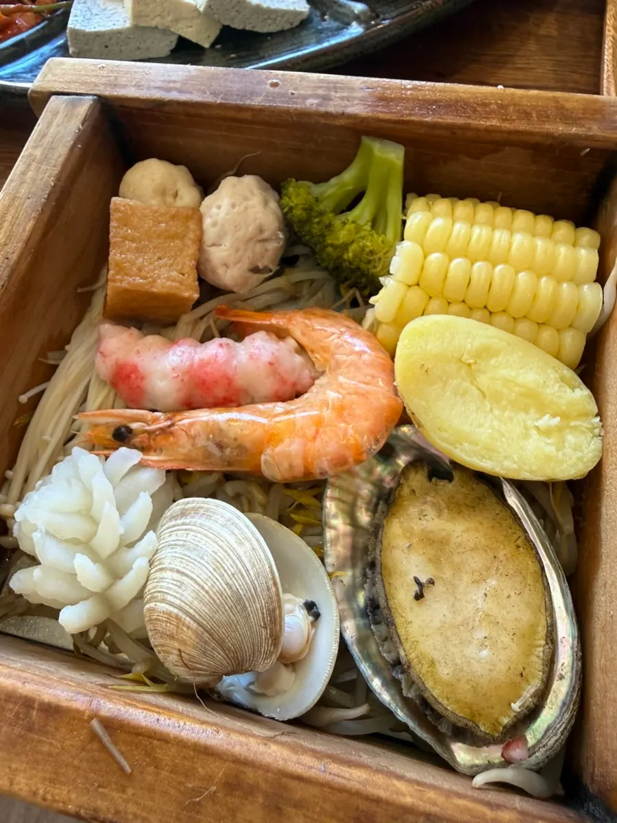 Hinoki steam filled with clams, squid, shrimp, and fish cake