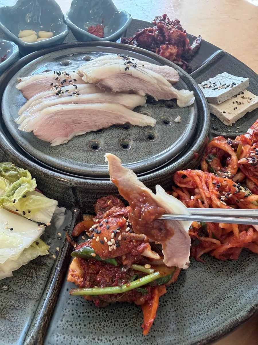 Basic side dishes at Songjeongok including kimchi and seasoned vegetables