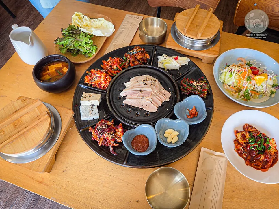 Abalone pot rice set surrounded by bossam and side dishes