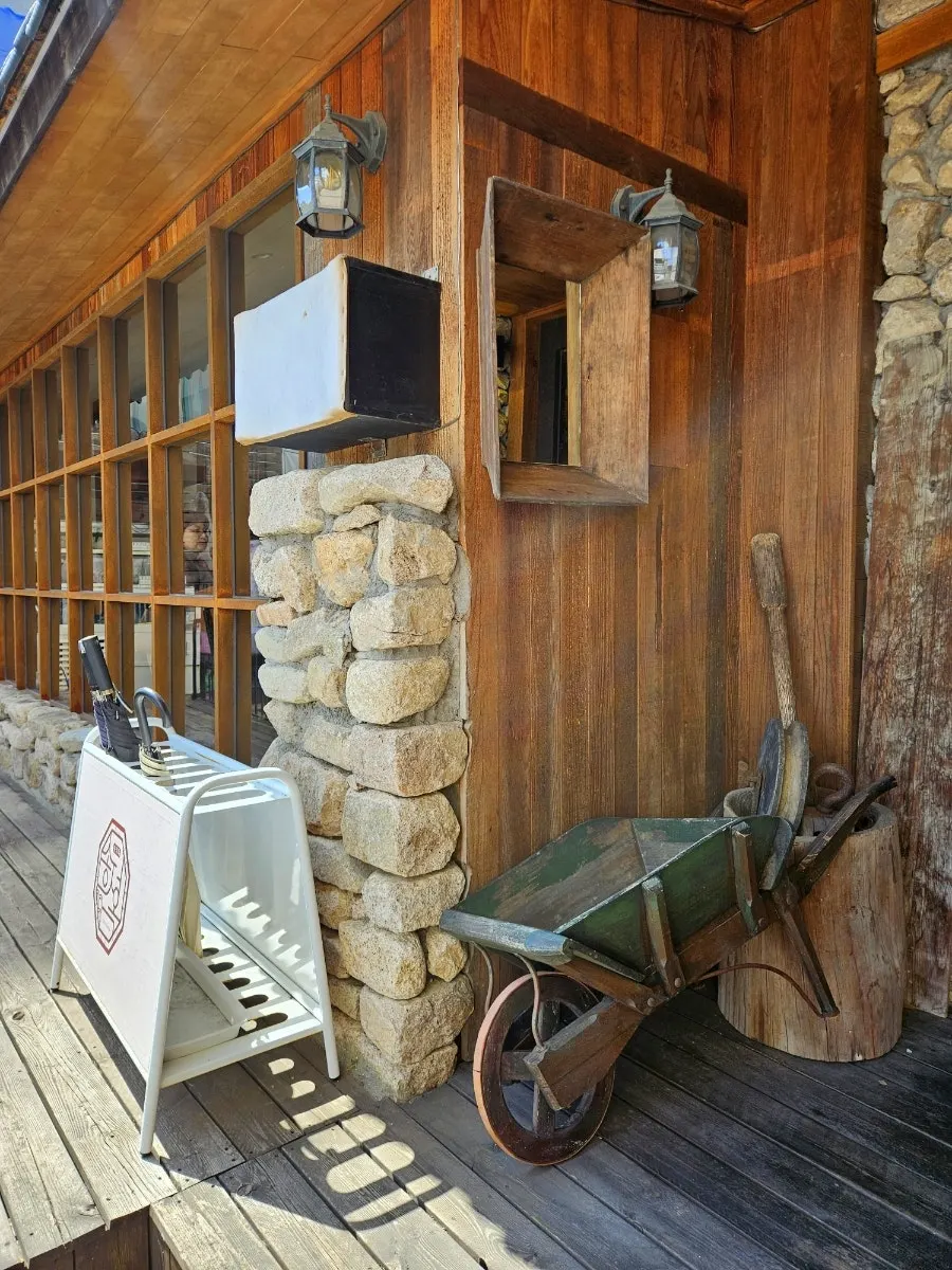 Old wooden cart and stone mortar props next to the entrance