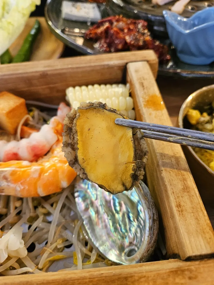 A large abalone pulled from the hinoki steam
