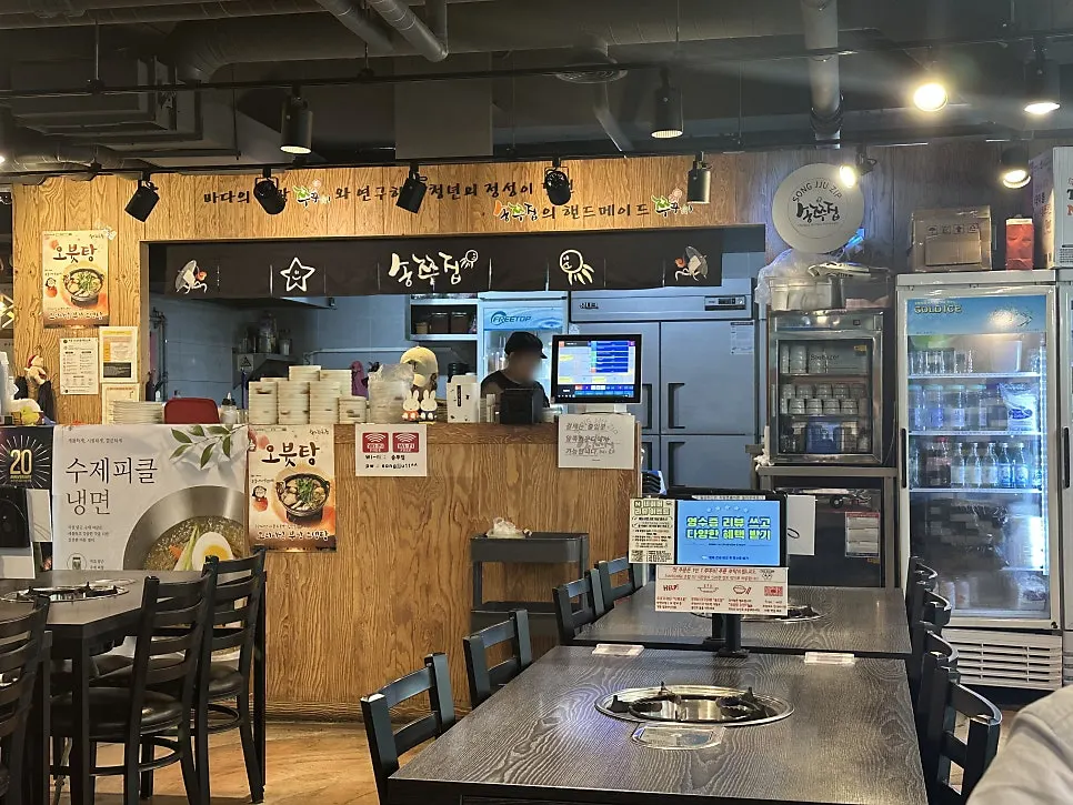 Restaurant interior with wood-toned decor and an open kitchen view